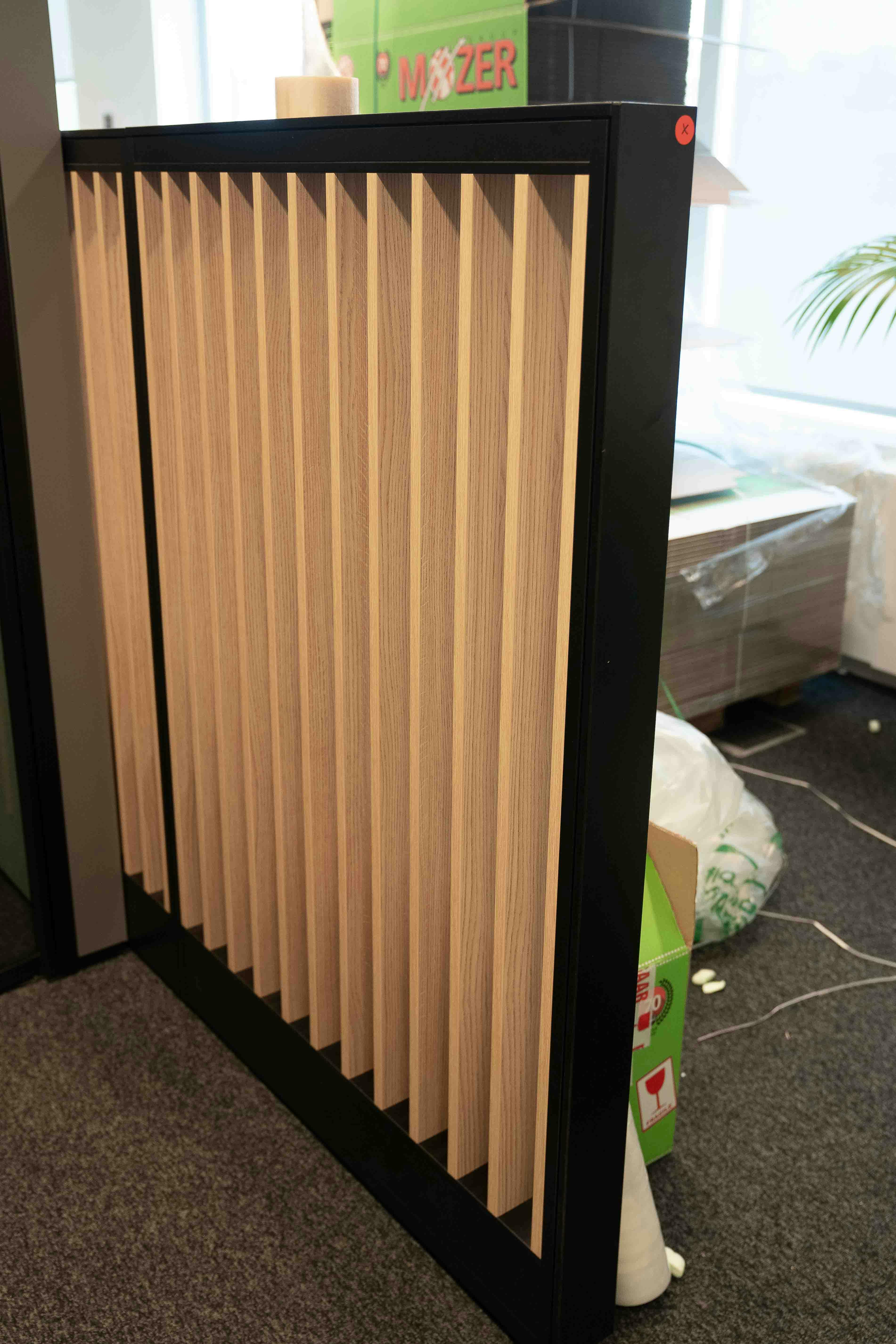 Natural Wood Slat Room Divider with Black support and a green/blue part in cushion - Relieve Furniture
