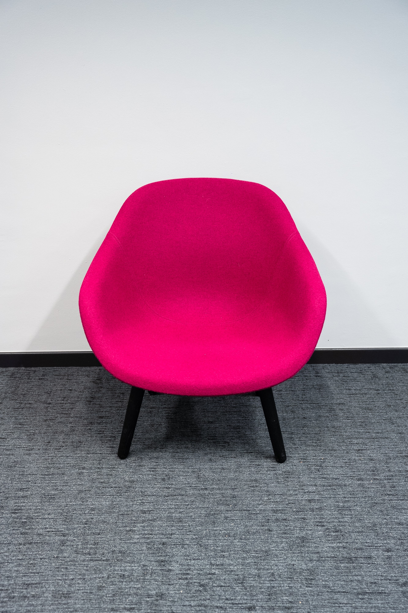 Fuschia armchair on black wooden legs