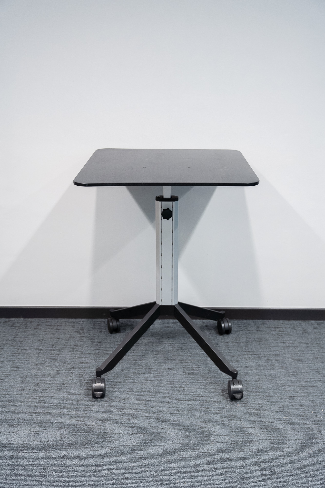 Black mobile table with height-adjustable on wheels