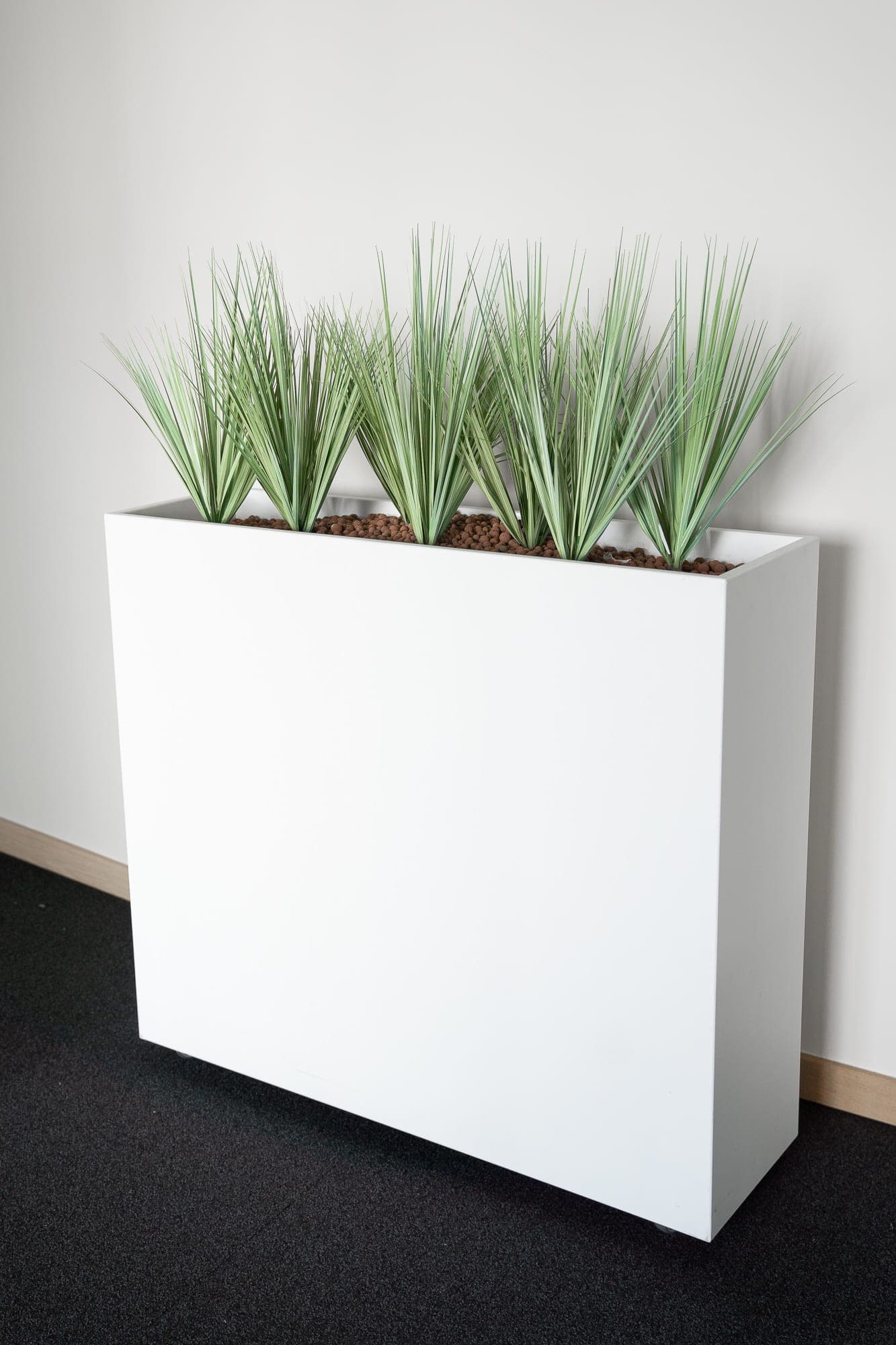 White planter with fake plants on wheels