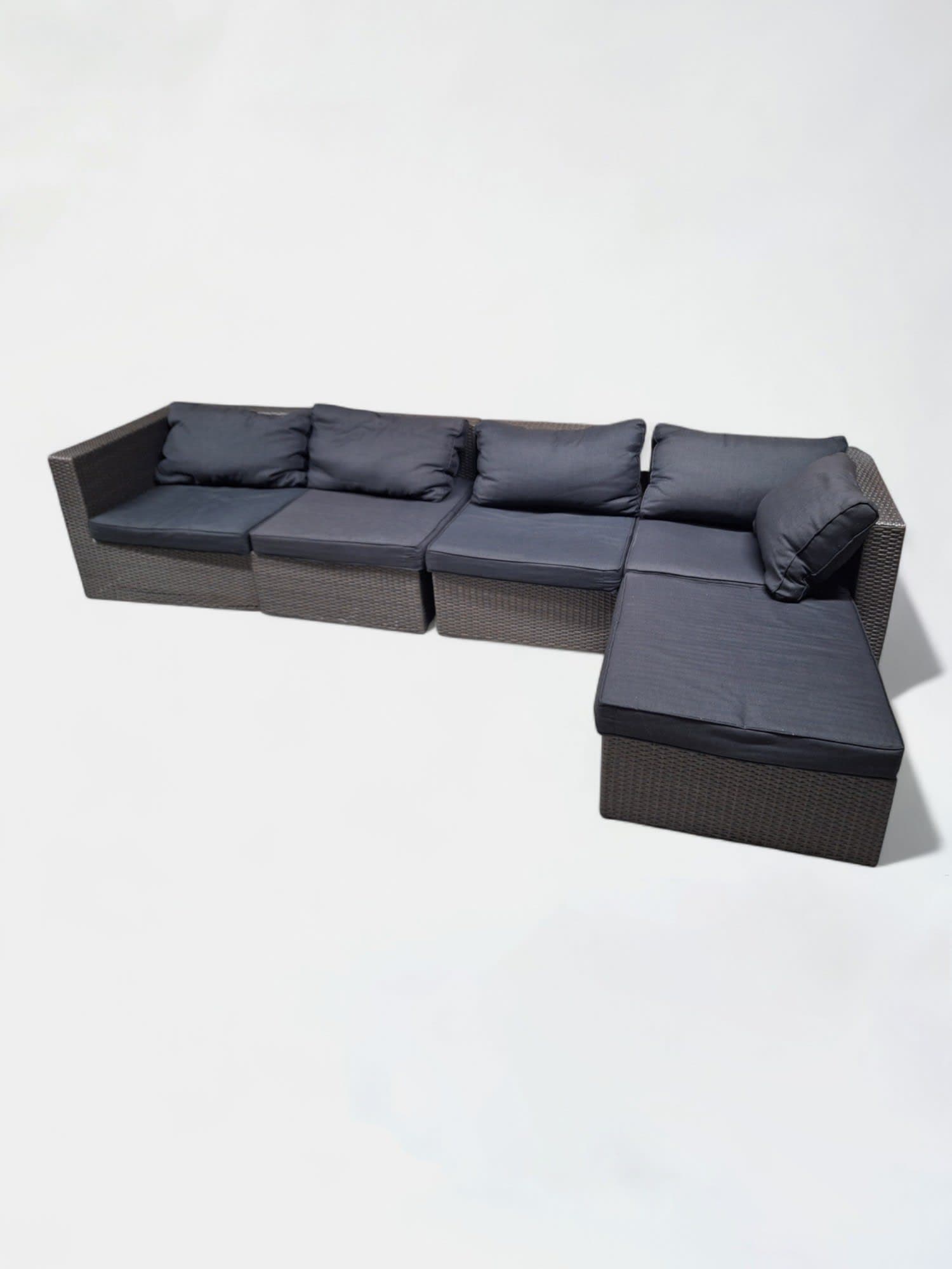 Bruine kunststof rieten modulaire buitenbank met zwarte kussens