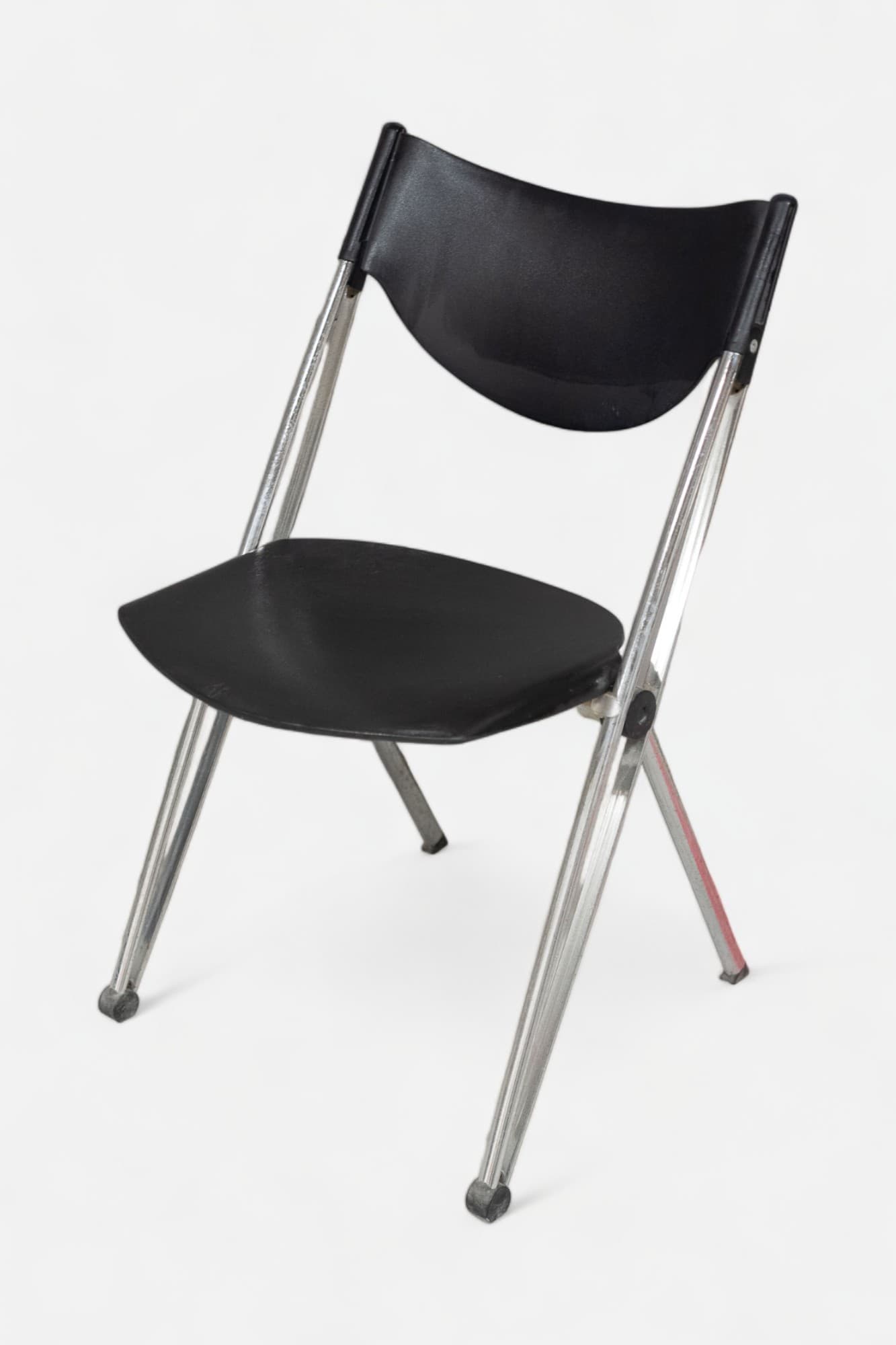 Black plastic folding chair with chrome legs and ergonomic design