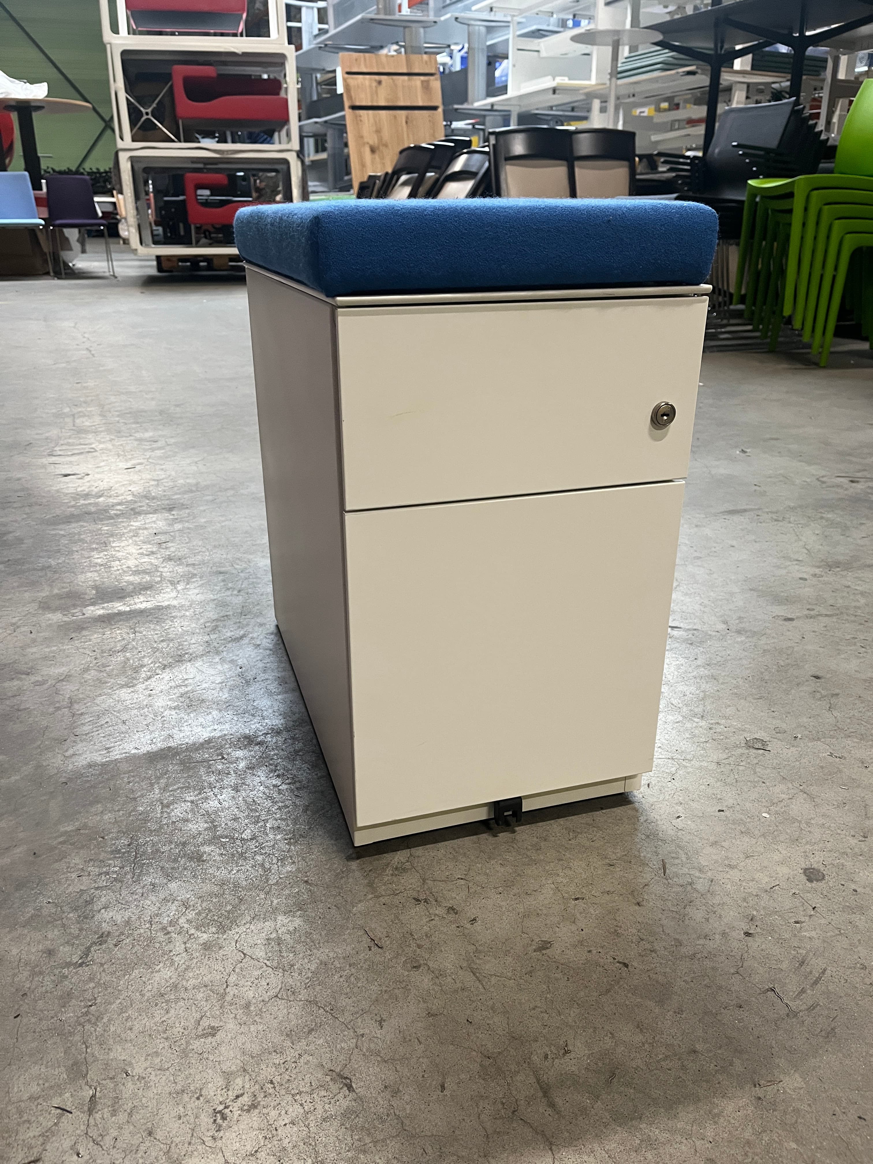 Meuble à tiroirs blanc avec dessus de coussin bleu en tissu