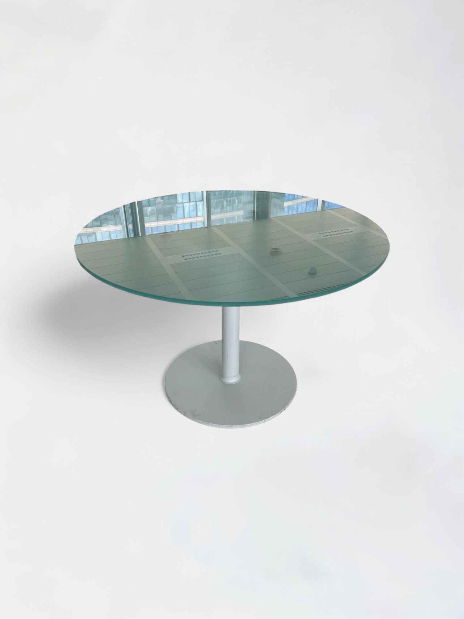 Table ronde en verre flou avec une structure en métal blanc