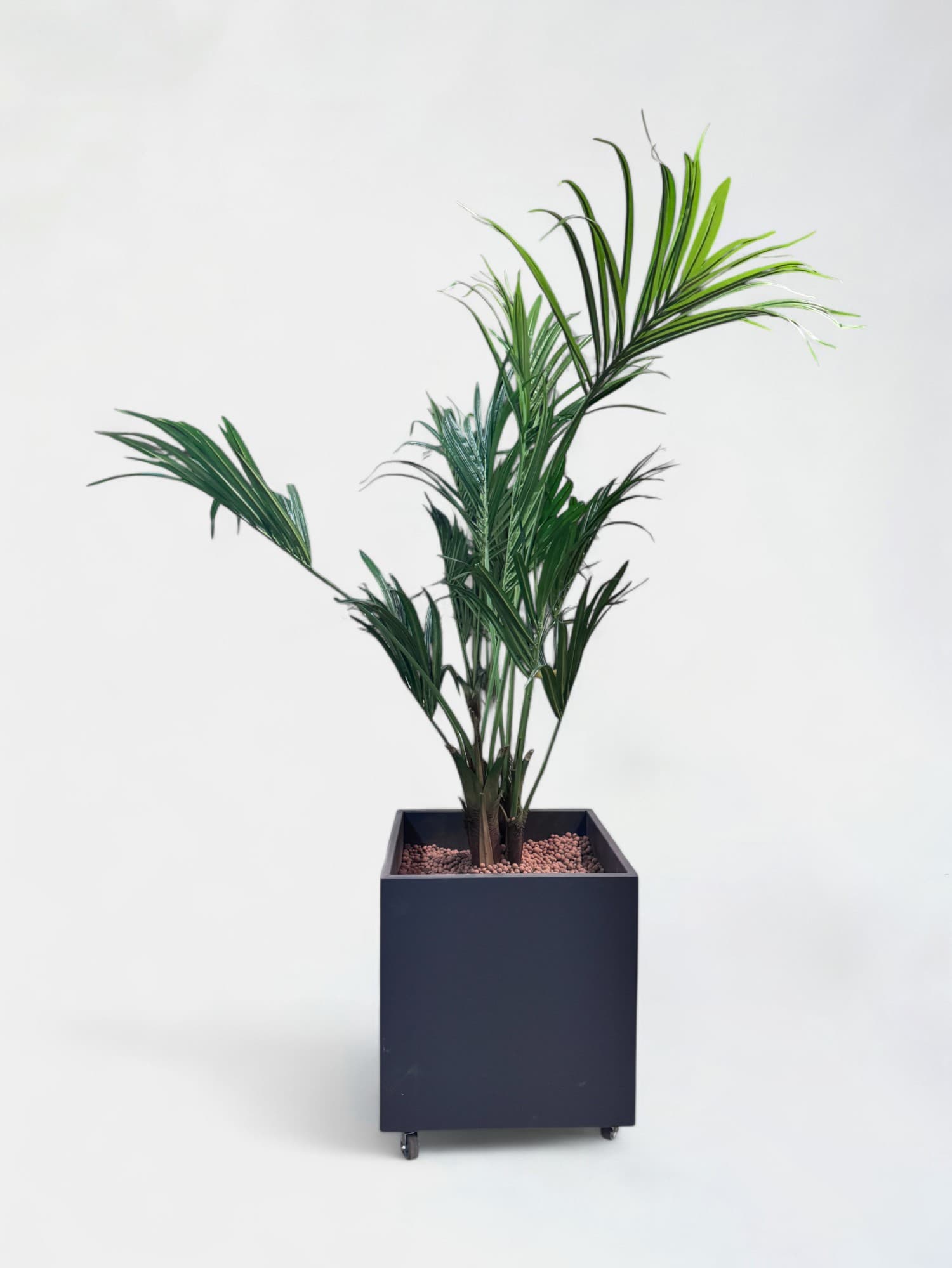 Fake plant in a dark gray square pot on wheels