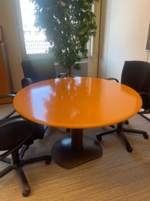 Table ronde en bois orange avec base noire