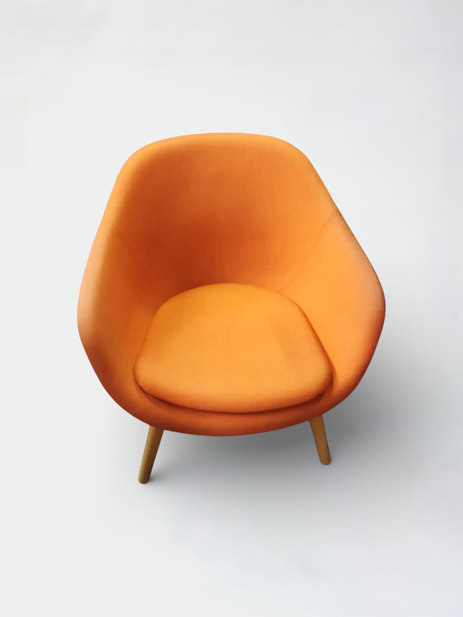 Orange armchair on wooden legs. Signs on use on the armrests