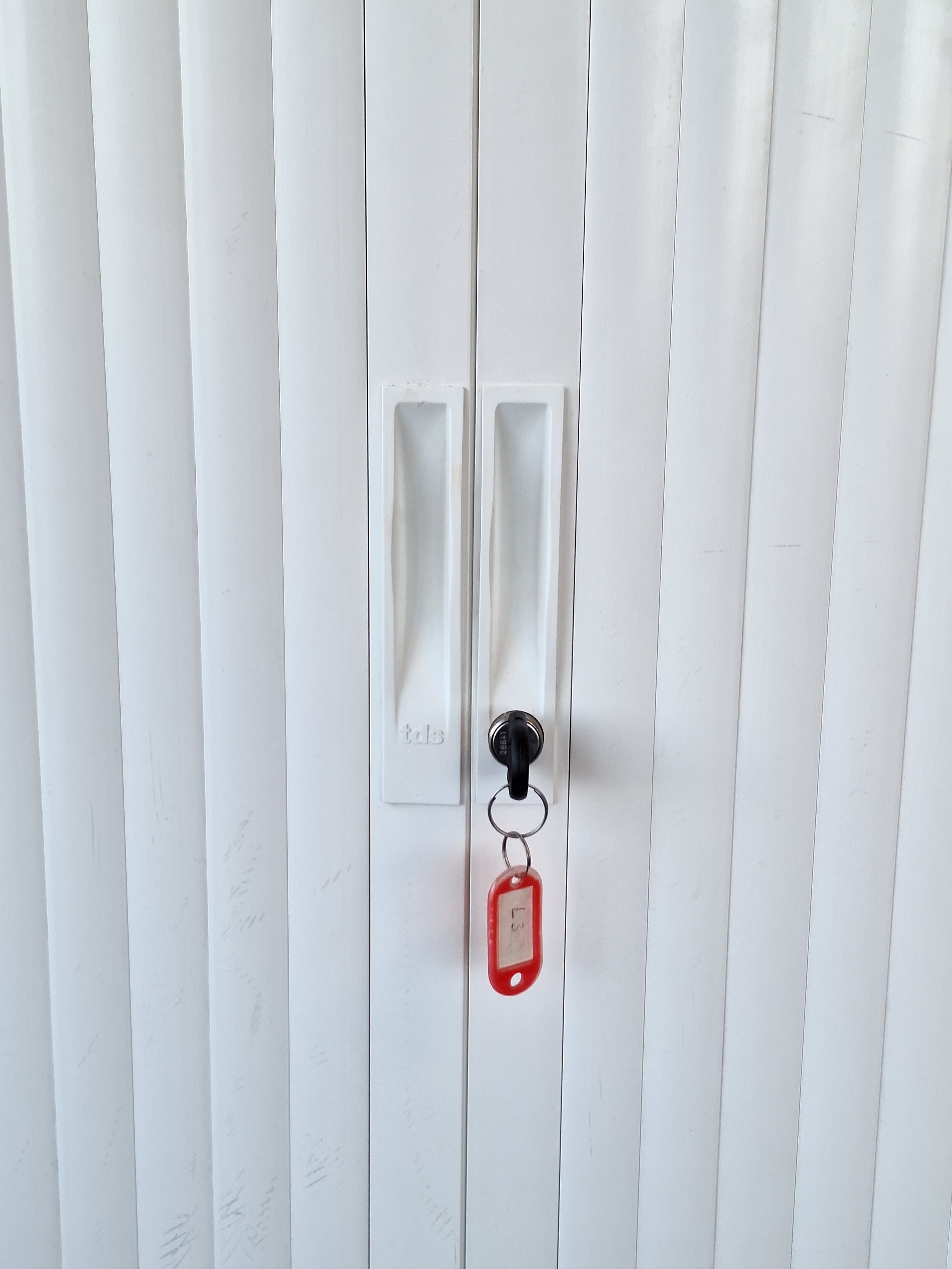 Wit metalen opbergmeubel met schuifdeuren met akoestisch paneel