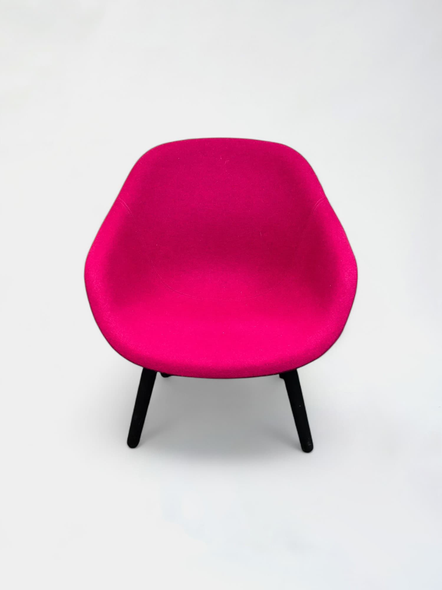 Fuschia armchair on black wooden legs