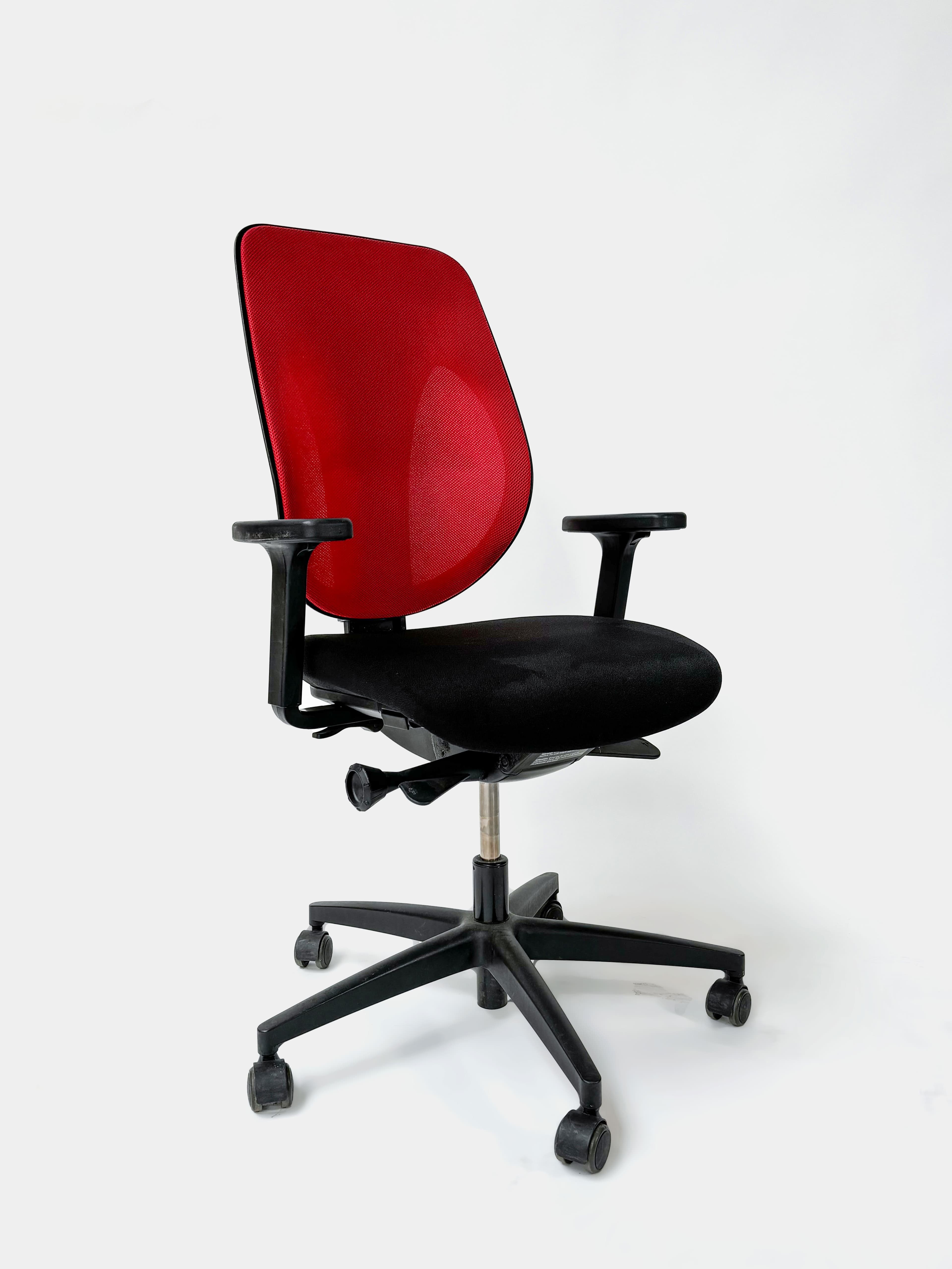ORIGINE : GIROFLEX Chaise de bureau ergonomique sur roulettes, rouge et noire, réglable. Fonctionnelle mais avec des rayures ou des taches ou défauts sur l'assise.