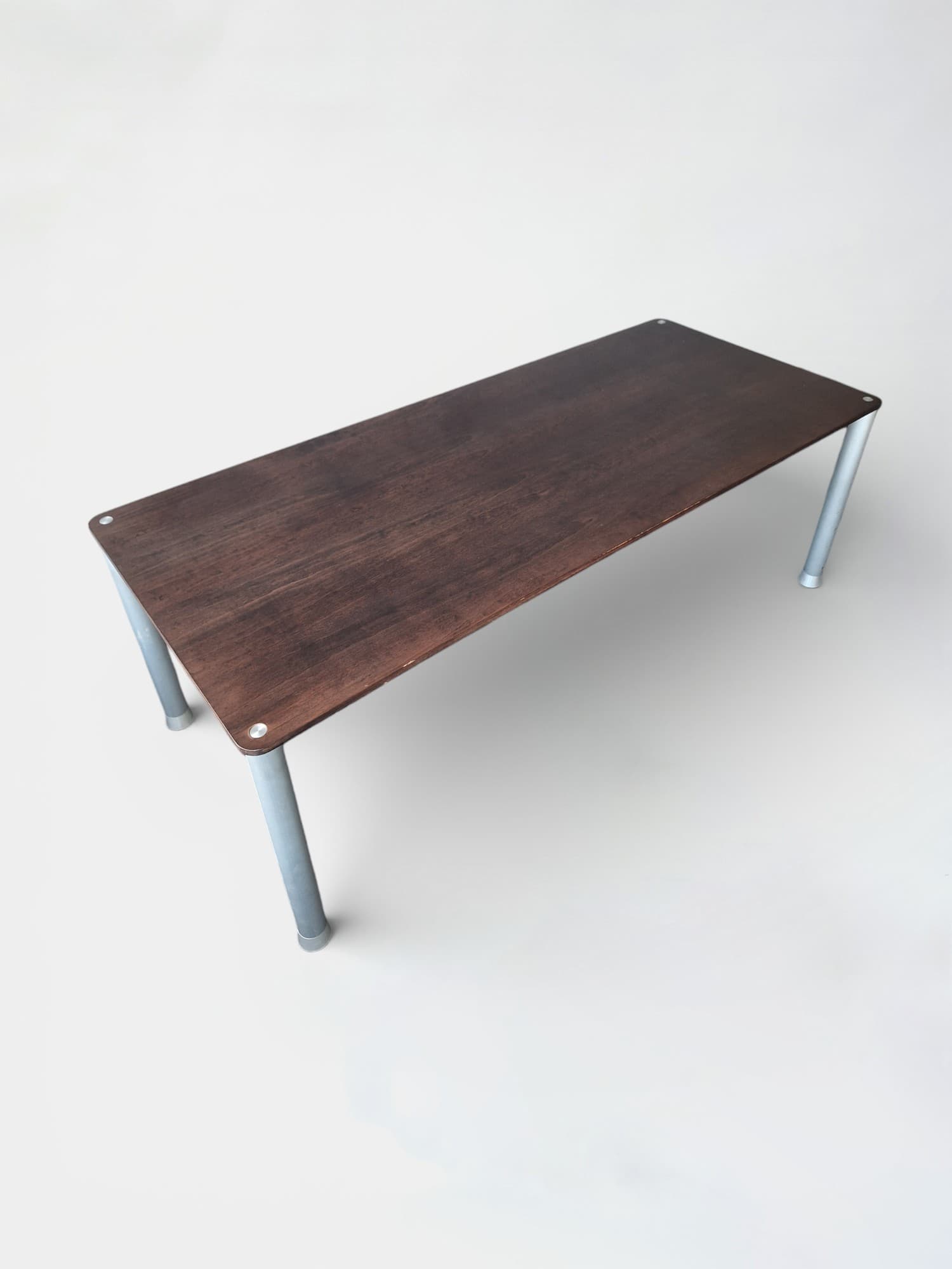 Donkerbruine houten tafel met metalen poten met gebruikssporen