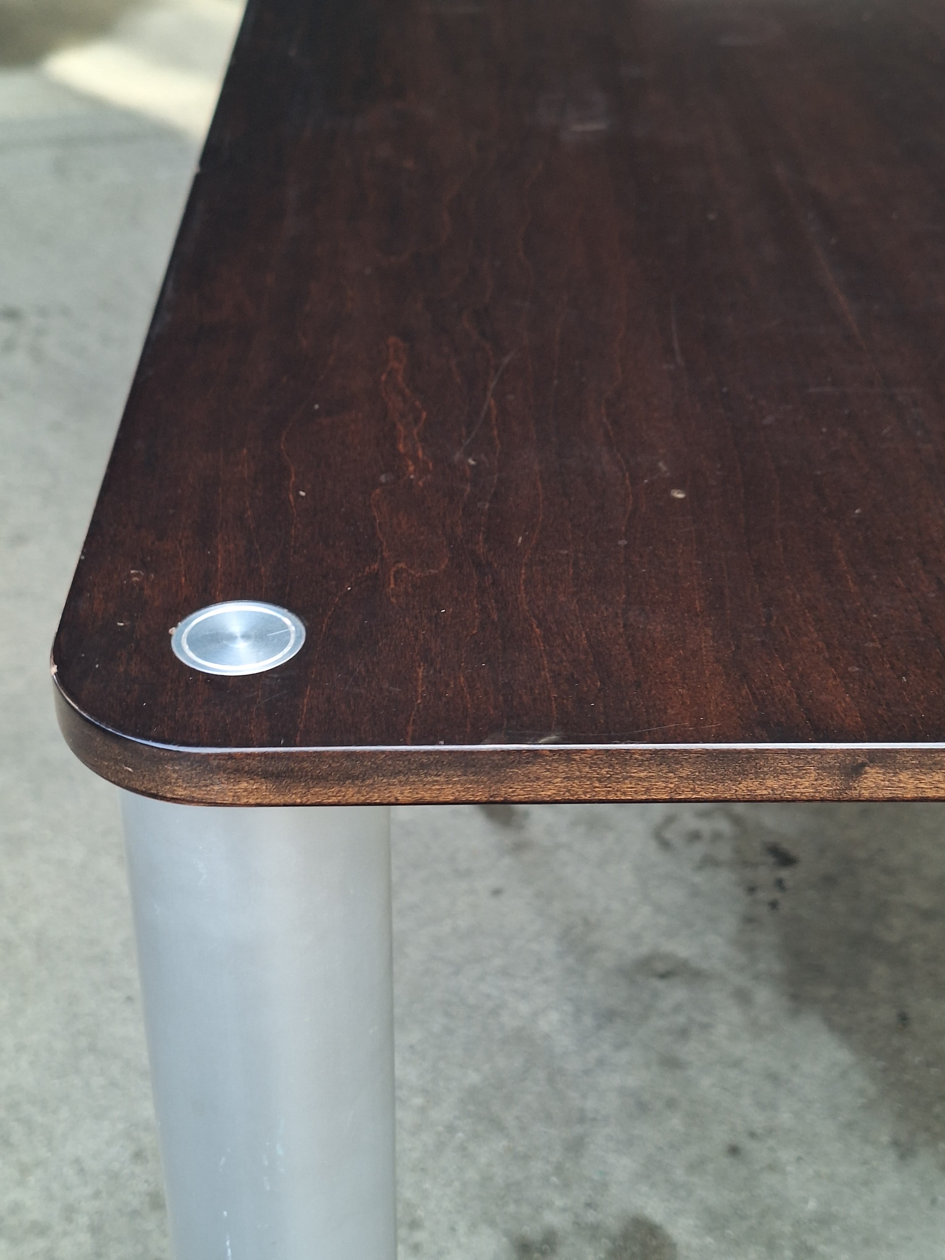 Donkerbruine houten tafel met metalen poten met gebruikssporen